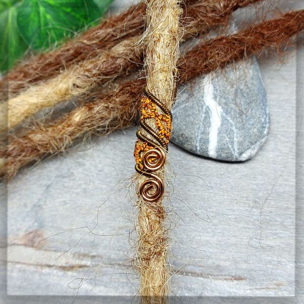 Dreadspirale in einem braun schwarz melierten Baumwollgarn geknotet und mit antikbronze Draht zu einer Spirale geformt