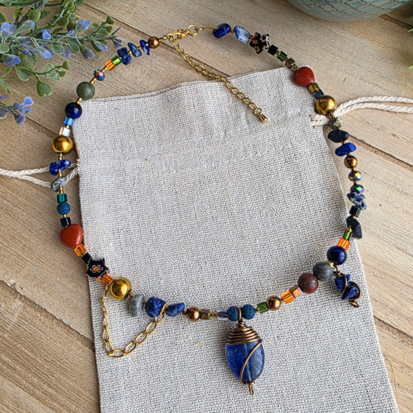 Halskette mit blauem Drahtanhänger, verschiedenen Edelsteinen, Glasperlen und goldfarbenen Schmuckelementen