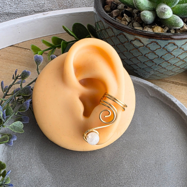Ear Cuff Vortex Goldfarben mit Mondstein an einem Silikonohr