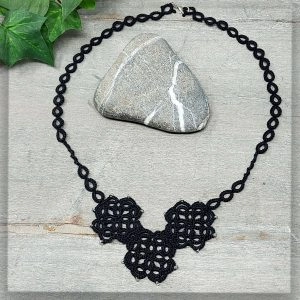 Halskette in schwarzem Garn geknotet und mit schimernden Glasperlen verziert.