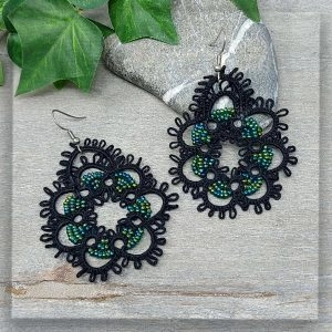 Ohrringe geknotet aus schwarzem Garn und mit grün schimmernden Glasperlen verziert mit Edelstahl Ohrhaken