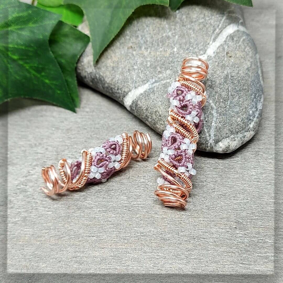 Schicker Dreadschmuck Dreadspiralen Set bestehend aus 2 Stück in der Farbe Roségold und antik violettem Baumwollgarn mit Milchig weißen Glasperlen