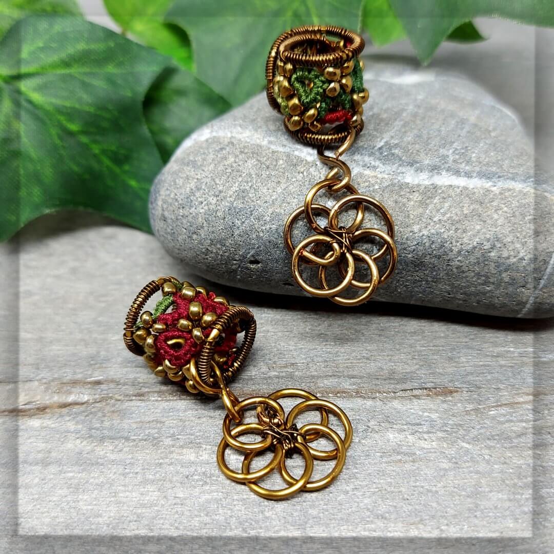 Dreadperlen Dreadschmuck aus Baumwollgarn geknotet in Grün- und Rottönen mit Antikbronze Draht stabilisiert und mit einem Anhänger einer Lebensblume aus Draht geformt verziert