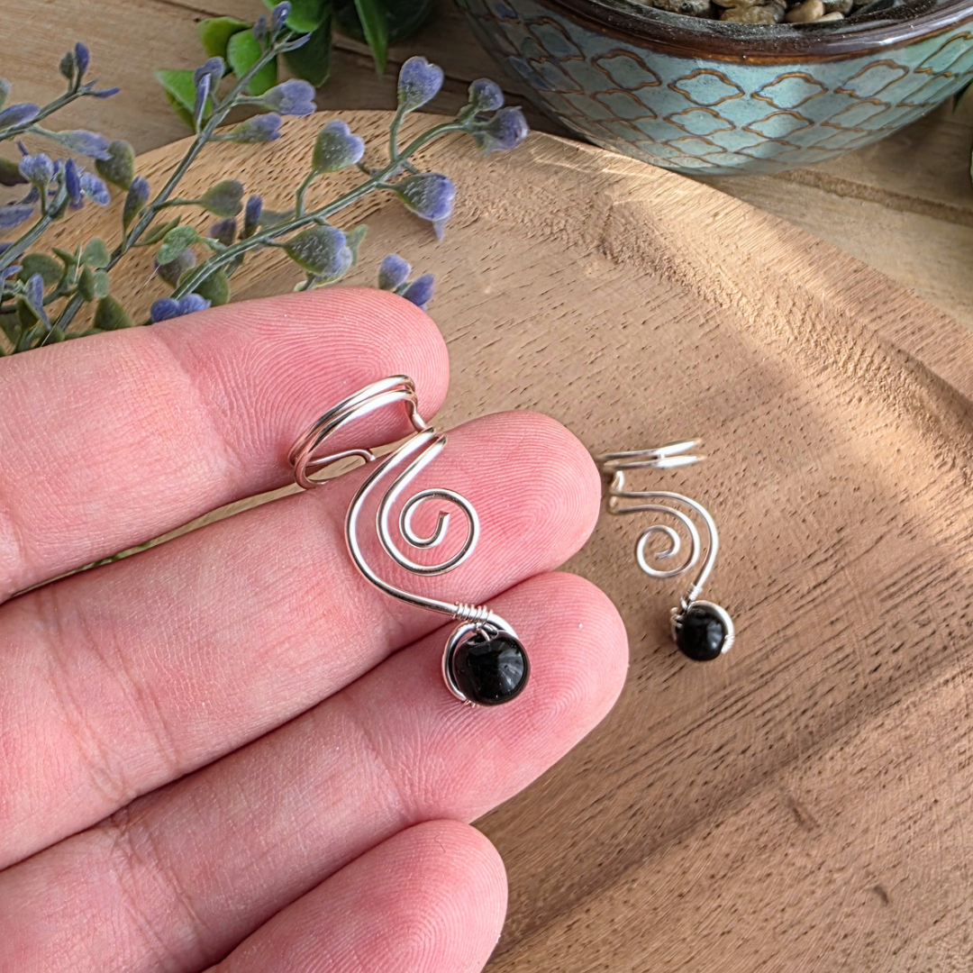 Silberfarbener Ear Cuff Vortex aus Draht mit Spirale und schwarzer Onyxperle, handgefertigt von MaMari Art®.