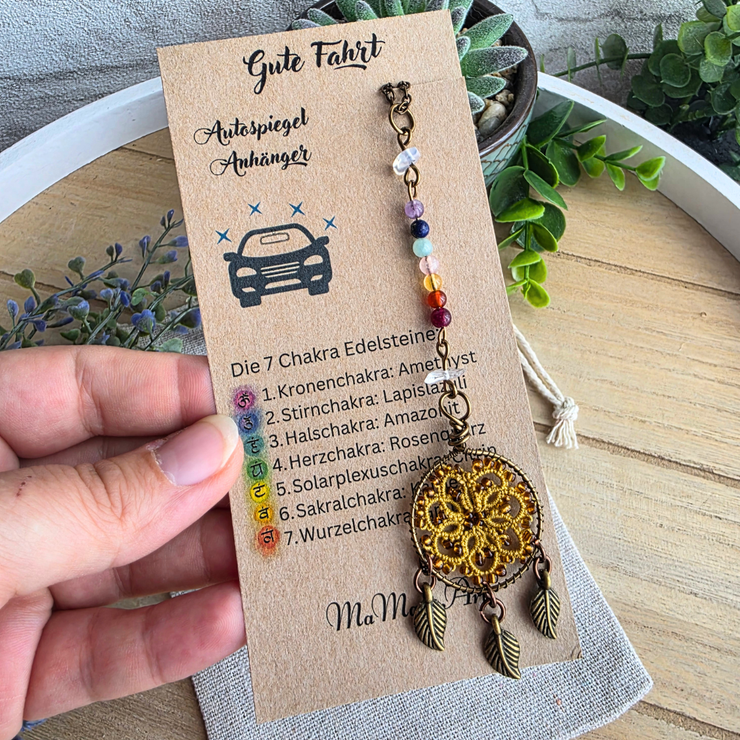 Autospiegel-Anhänger Traumfänger Harvest Gold mit Chakra-Edelsteinen und goldfarbener Occhi-Spitze auf Produktkarte.