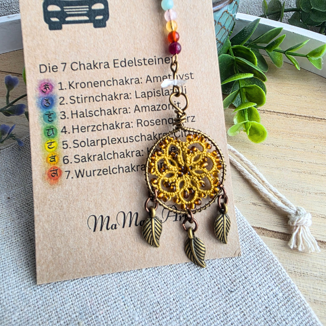 Detailaufnahme des handgefertigten Traumfänger-Autospiegel-Anhängers Harvest Gold mit sieben Chakra-Edelsteinen und Blattanhängern.