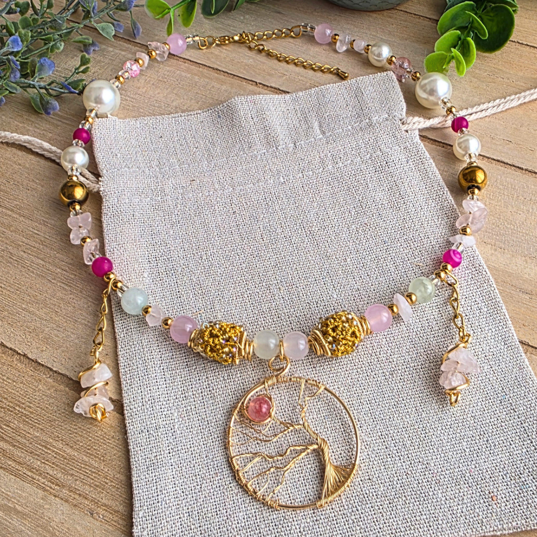 Handgefertigter Halsreif in Rosa, Pink und Gold mit verschiedenen Glas- und Edelsteinperlen, Rosenquarzsplittern und großem goldfarbenen Lebensbaum-Anhänger