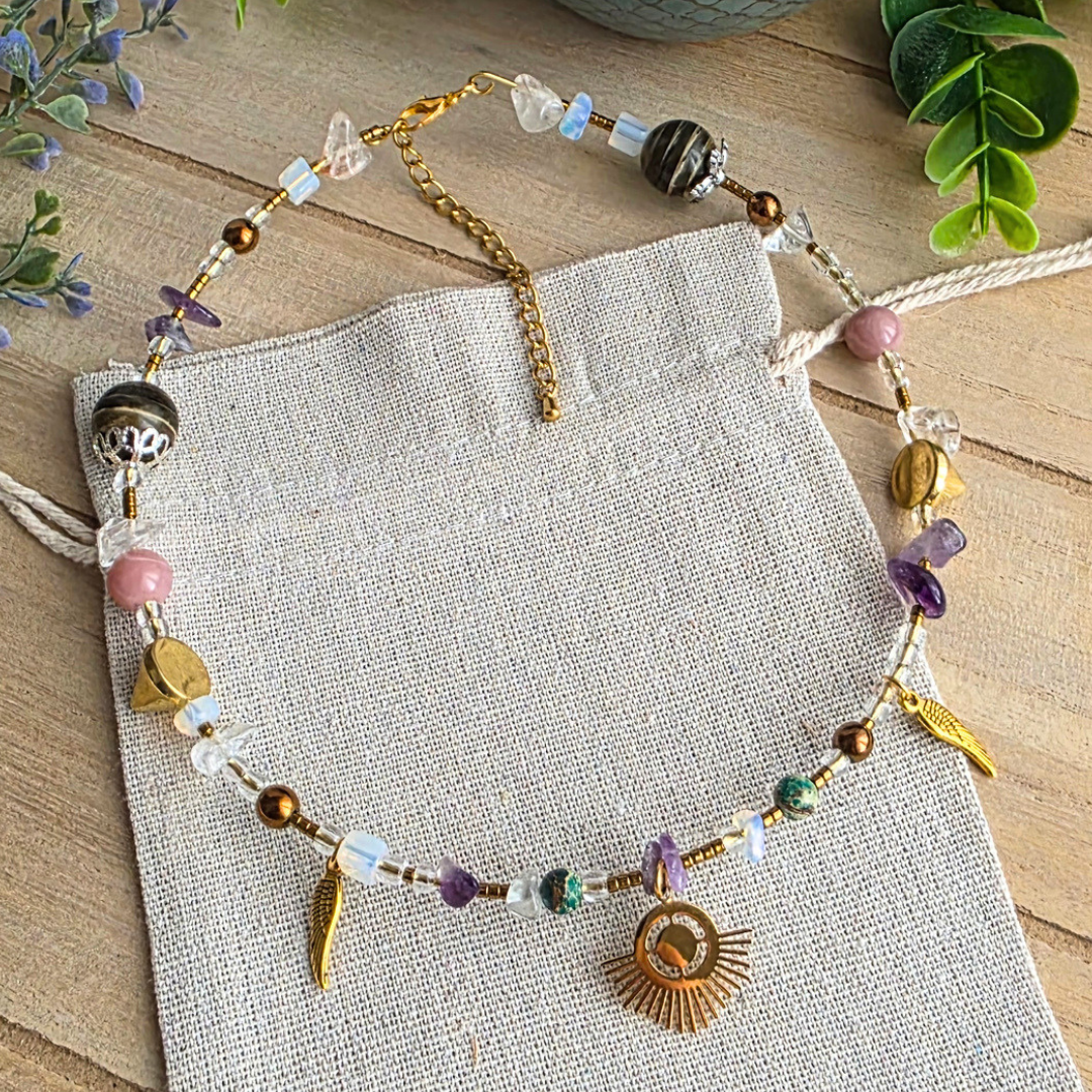 Handgefertigter Halsreif mit lila Amethystsplittern, verschiedenen Glas- und Steinperlen, goldfarbenen Akzenten, zwei Flügeln und einem Sonnenanhänger