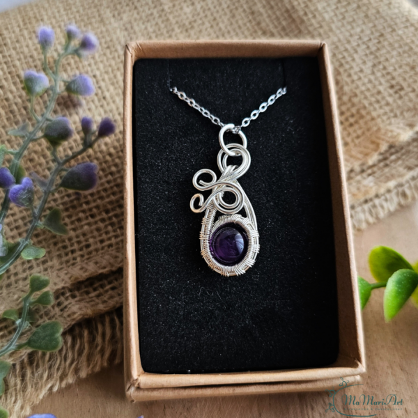 Silberne Halskette mit einem lila Amethysten filigran in silbernem Draht eingefasst. in einer Schmuckschachtel