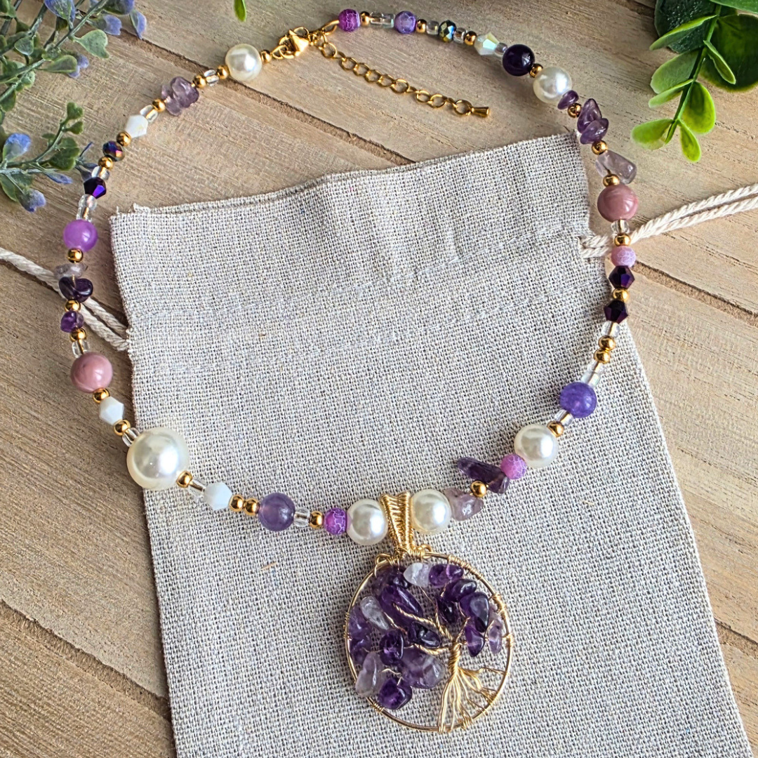 Halsreif mit Amethyst, violetten und weißen Perlen sowie goldfarbenen Details und einem handgefertigten Lebensbaum-Anhänger mit Amethystsplittern