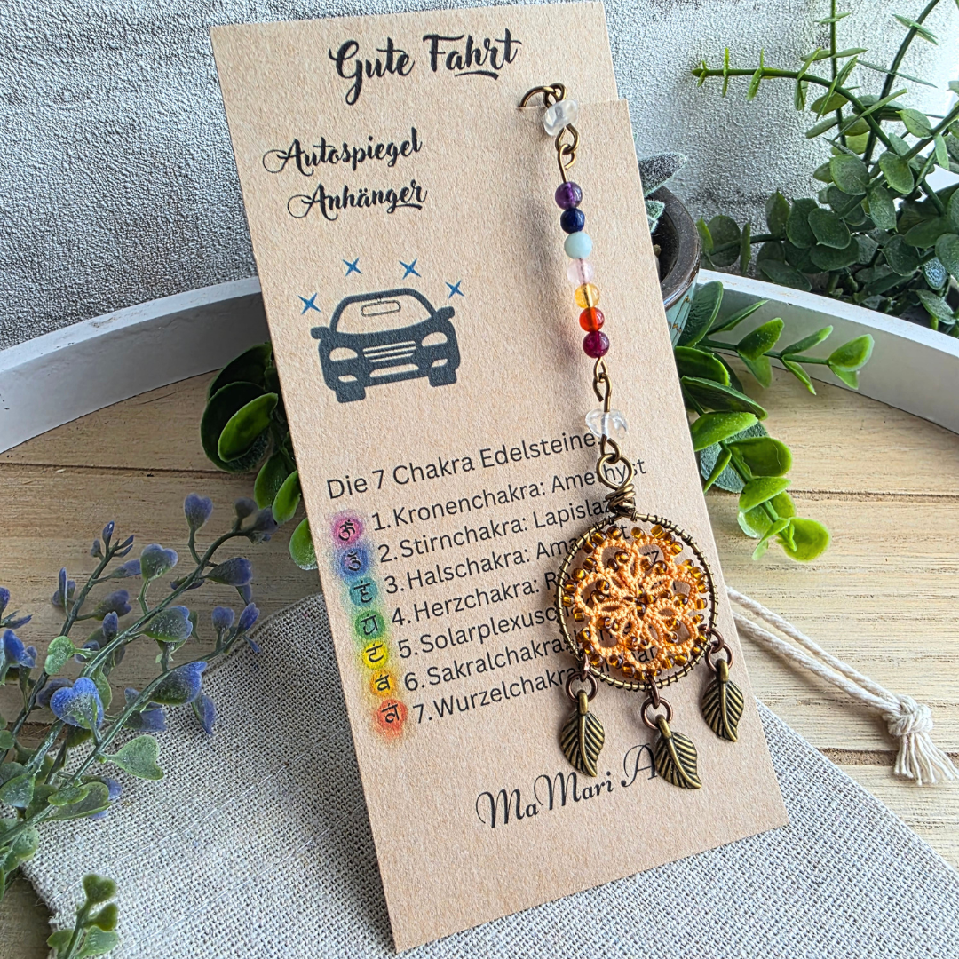 Autospiegelanhänger Chakra Traumfänger Autumn Orange mit sieben Chakra-Edelsteinen, Occhi-Motiv und drei antikbronzenen Blättern auf Produktkarte.