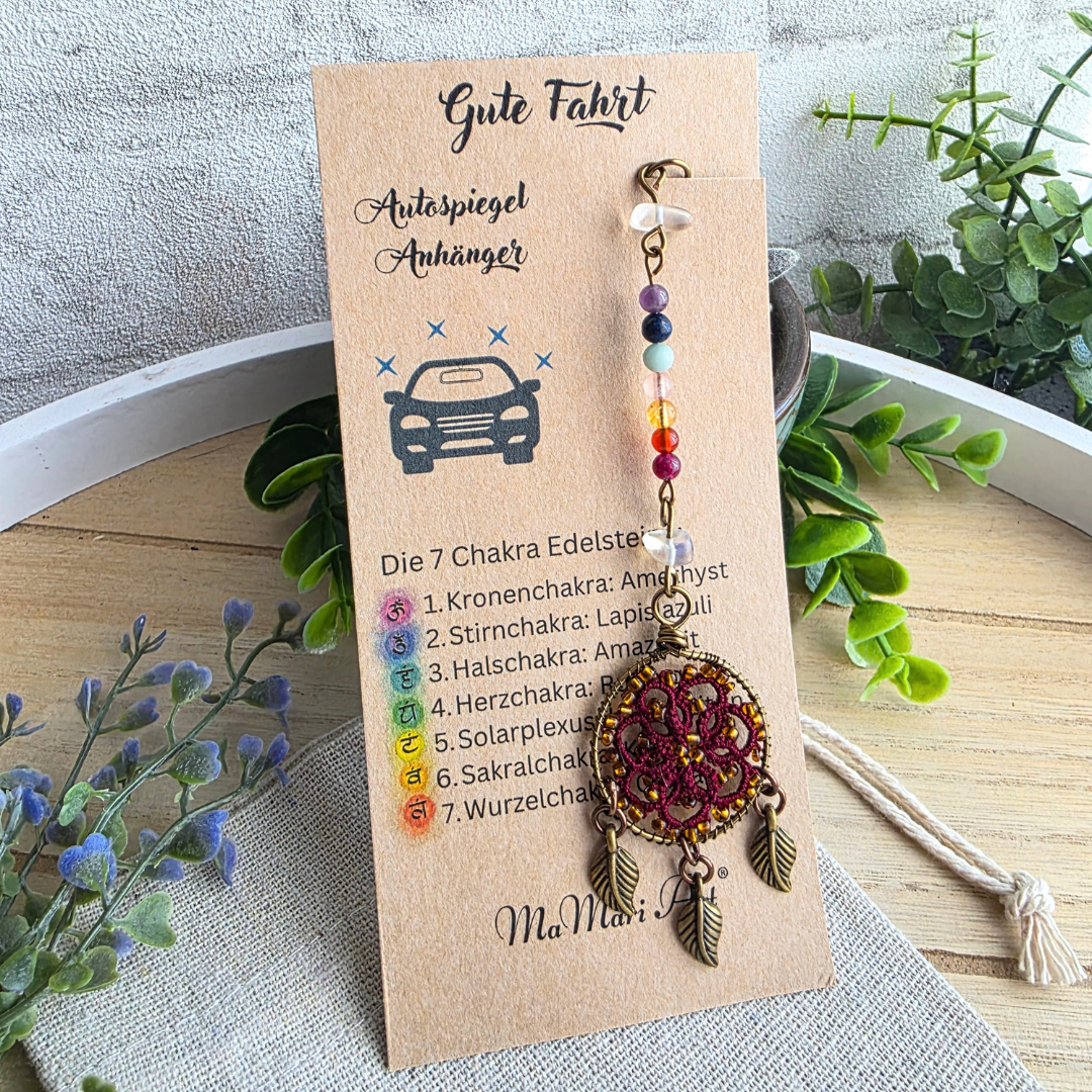 Autospiegelanhänger Chakra Traumfänger in Bordeauxrot mit sieben Chakra-Edelsteinen, Occhi-Motiv und drei antikbronzenen Blättern auf Produktkarte.