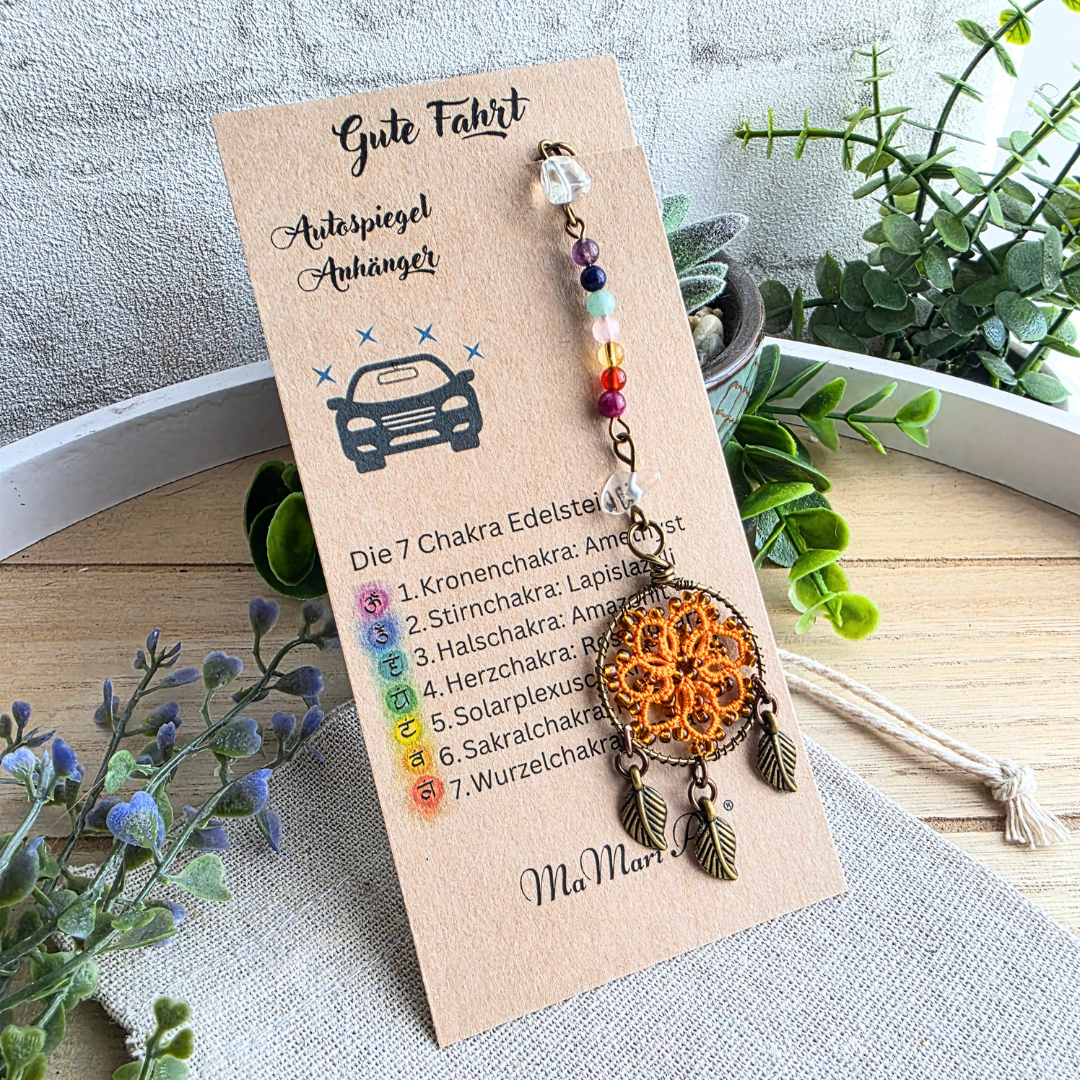 Autospiegelanhänger Chakra Traumfänger in Orange mit sieben Chakra-Edelsteinen, Occhi-Motiv und drei antikbronzenen Blättern auf Produktkarte.